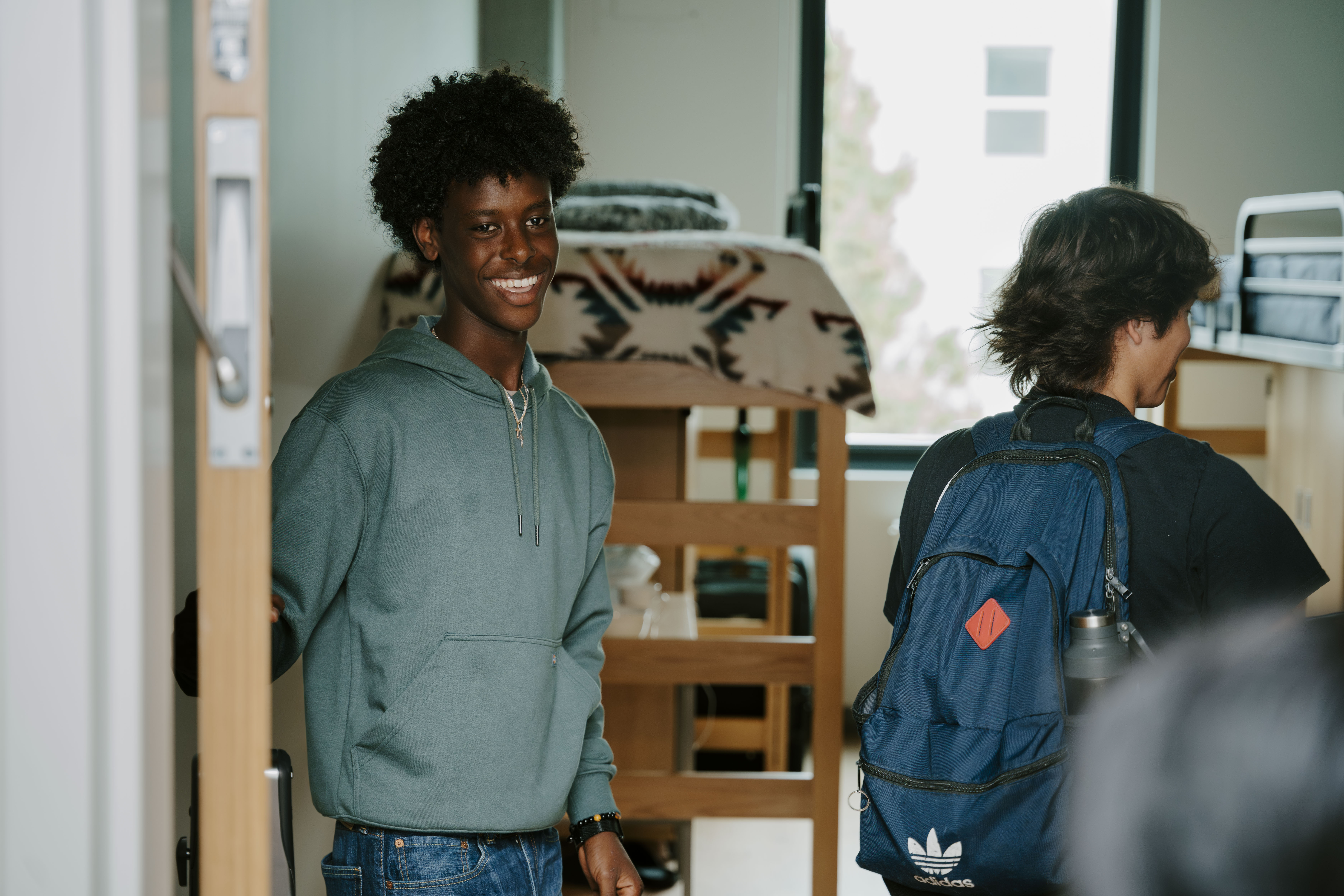 Student in doorway of room at West Grove Commons