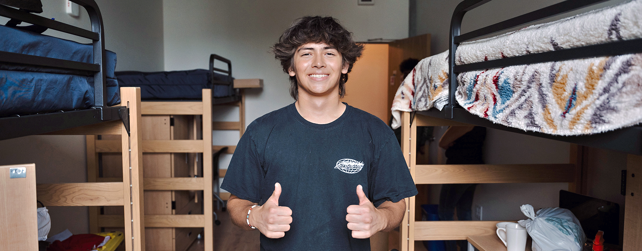 Student giving thumbs up in residence hall room