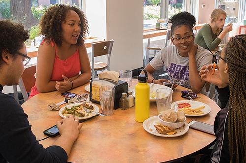 Students talking and sharing a meal at the residential dining commons