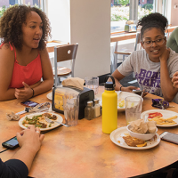 Students talking and sharing a meal at the residential dining commons