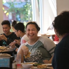 Student laughing while eating at dining center