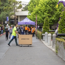 Student walking with moving bin on move-in day