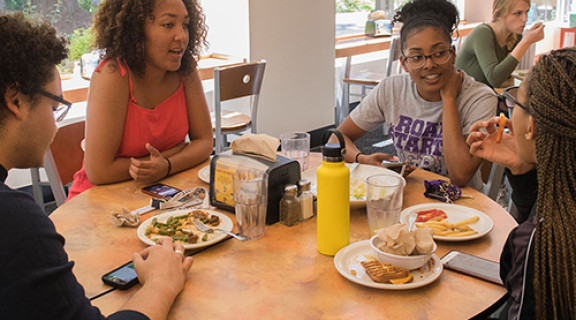 Students talking and sharing a meal at the residential dining commons